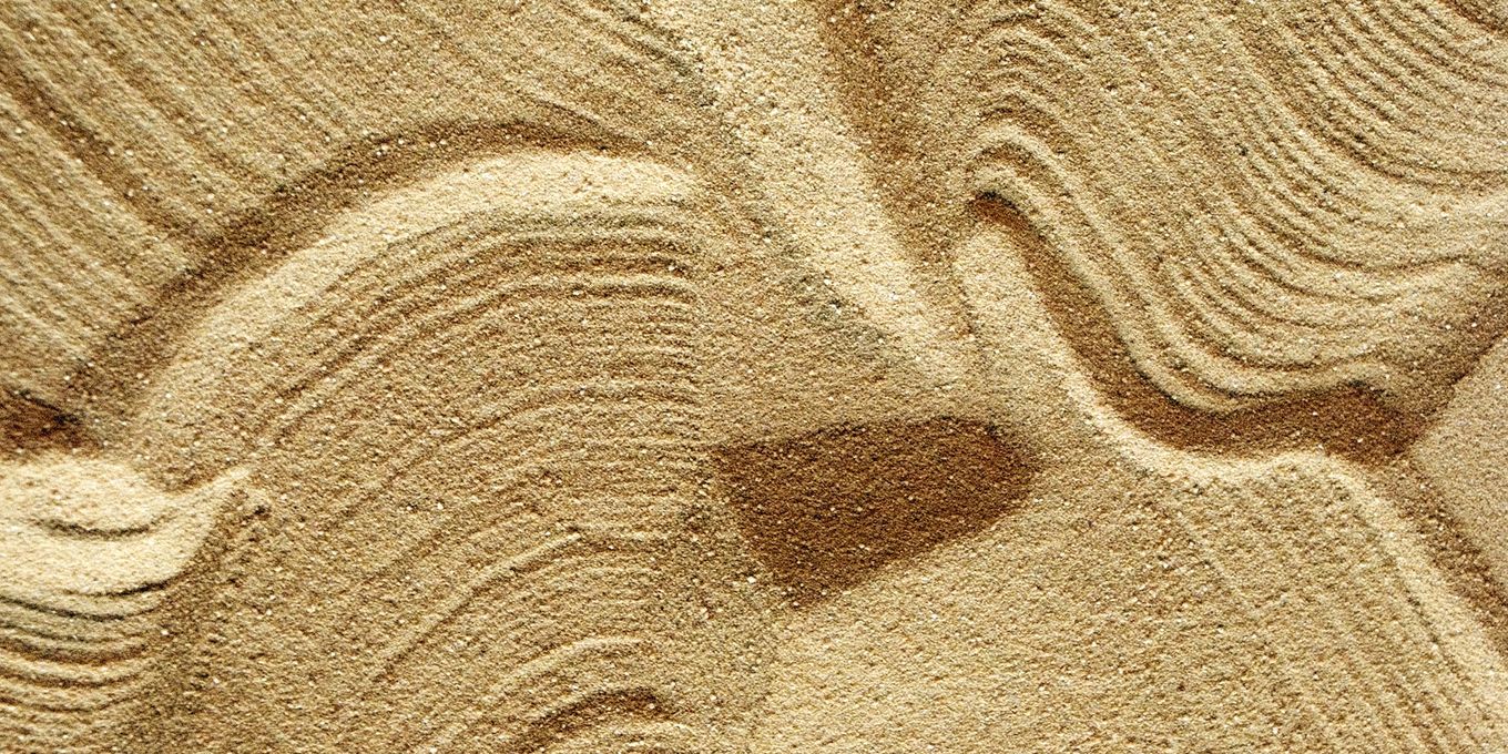 Wind-shaped ripples and grooves in pale sand